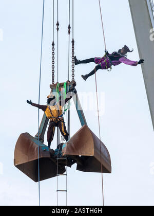 ENSCHEDE, THE NETHERLANDS - NOV 16, 2019: Two black peter’s’ the helping hand of the dutch Santa Claus’ are climbing in a crab crane. Stock Photo