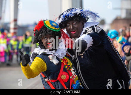 ENSCHEDE, THE NETHERLANDS - NOV 16, 2019:  Black pete is the helping hand of the dutch Santa Claus called Sinterklaas. On the photo two of them. Stock Photo