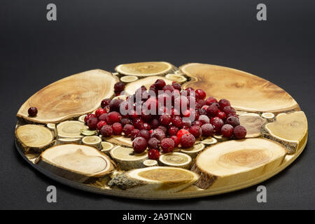 Frozen berries cranberries on a tray made of wooden circles Stock Photo