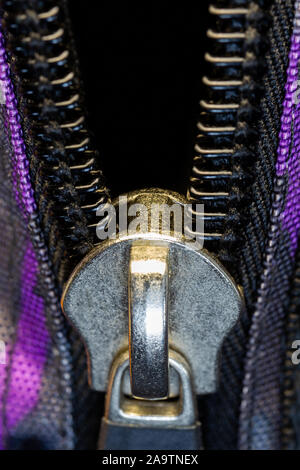 Close-up open zipper with metal lock and plastic teeth. Items of clothing Stock Photo