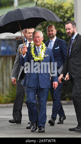 The Prince of Wales shelters from the rain under an umbrella during a visit to Wesley Community Centre in Auckland, on the second day of the royal visit to New Zealand. Stock Photo