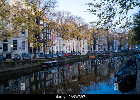 Amsterdam, Netherlands - November 9, 2019: Buildings and house boats along canal during an early autumn fall morning in the Jordaan neighborhood Stock Photo