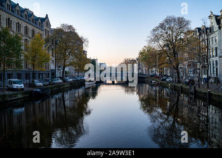 Amsterdam, Netherlands - November 9, 2019: Buildings and house boats along canal during an early autumn fall morning in the Jordaan neighborhood Stock Photo