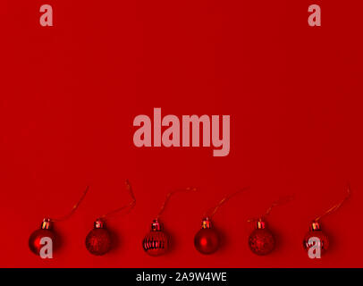 Red Christmas decorations on a red background. balls at the bottom of the frame. Place for text. Minimal. Stock Photo