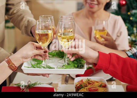 Hands of Christmas dinner guests taking champagne glasses form tray Stock Photo