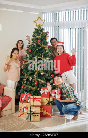Happy big Vietnamese family posing of beautiful decorated Chirstmas tree Stock Photo