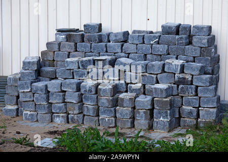 paving stones stacked in piles at the house wall for construction of driveway to garage Stock Photo