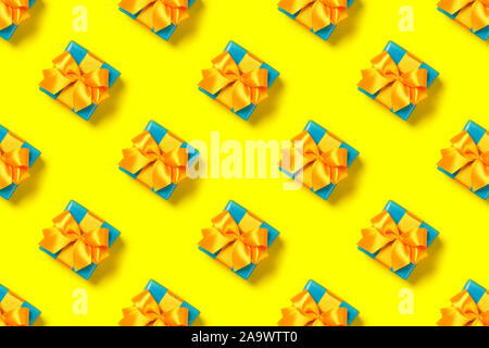 Pattern with stylish gift on a trendy yellow background. Present for St. Valentine's day, engagements, Mother's Day, birthday, New Year, Christmas, holidays Stock Photo