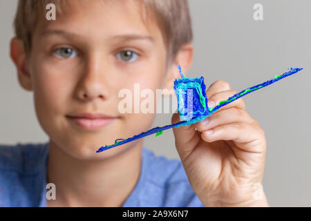 Kid creating with 3d pen and enjoy his new blue plane Stock Photo