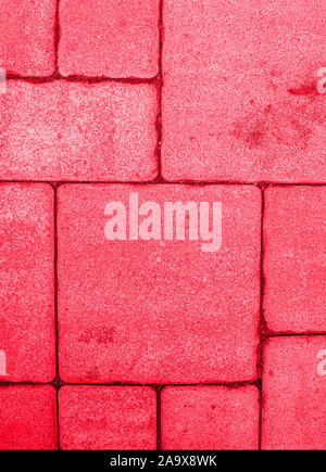 Close-up of geometric pattern of highly detailed street pavement made of square blocks. Textured rough surface toned in bright red color. View from ab Stock Photo