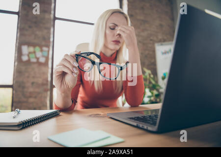 Close up photo of tired frustrated overloaded woman senor manager sit table use computer have much work feel tired migraine hold specs touch nose in