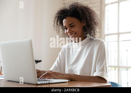 African american international company worker sitting at table with computer. Stock Photo