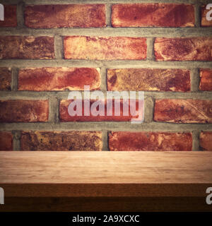 Wooden table against red brick wall, rustic background Stock Photo