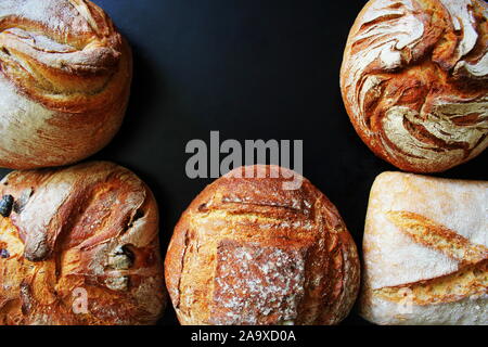 Bread. Assortment of different types of bread on a blackn background. Loaf, bun, baguette, cereal bread. Bakery products. Stock Photo
