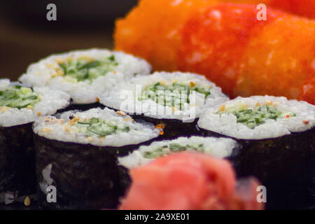 Mix of sushi rolls served on a plate in a restaurant. Japanese food