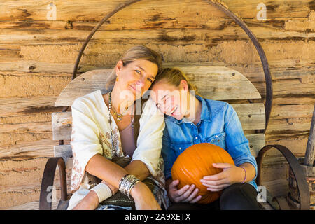 portrait of mother and her teen age daughter holding pumpkin Stock Photo