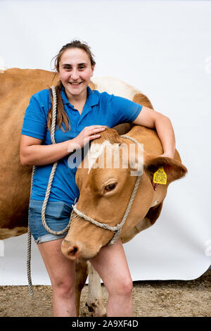 Portrait of smiling female farmer with a Guernsey cow. Stock Photo