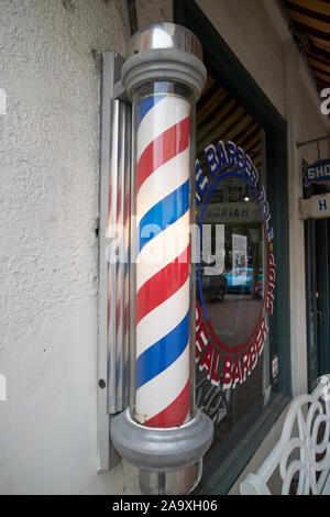 blue and white illuminated barbers pole outside barber shop in downtown savannah georgia usa Stock Photo