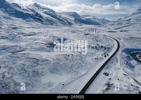 Aerial view of a winding road among the snowy mountains in the north of Iceland Stock Photo