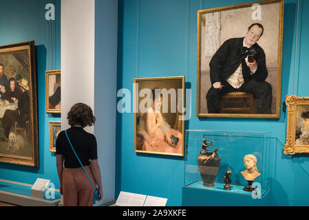 Young woman painting, rear view of a young woman looking at 19th century portraits inside the Nationalmuseum of Art, central Stockholm, Sweden. Stock Photo