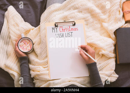 Woman thinking about Christmas presents and drinking hot chocolate Stock Photo