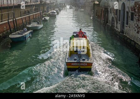 Venice, Italy Venetian water ambulance sailing on the canals. Venezia Emergenza medical boat with personnel aboard & 118 emergency phone number on top Stock Photo