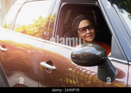 Happy senior woman in sunglasses driving a car. Stock Photo