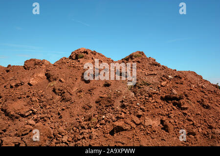 pile soil or dirt isolated on blue sky background in summer, dry soil pile and azure sky Stock Photo