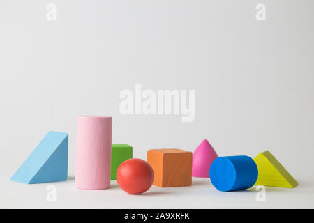 Colorful 3D wooden geometric shapes isolated on white background. Space for copy. Stock Photo