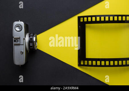 Flat lay of retro photo camera and film frame. Taking photos minimal creative concept. Stock Photo