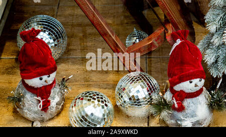 Snowman toy in a hat under the Christmas tree. Stock Photo