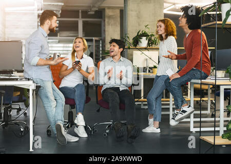 Young coworkers having pleasant talk in office Stock Photo