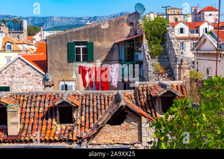 Cozy old house with green window shutters and bright linen within Diocletian Palace in Old Town of Split, the second largest city of Croatia Stock Photo