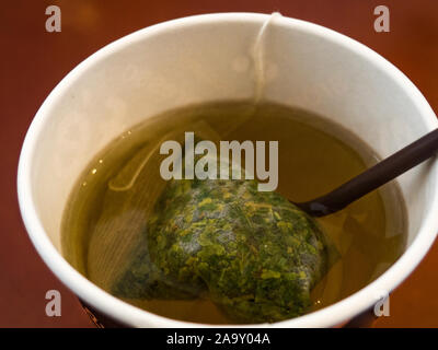 Bag tea of coca leaves in water in paper cup Stock Photo