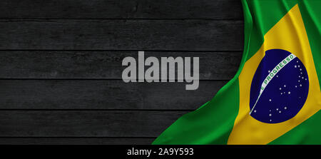 Flag of the Brazil, fabric on dark wood. Stock Photo