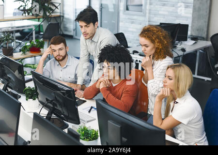 Pensive colleagues reading business information on computer Stock Photo