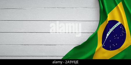 Brazilian flag, on top of white wood. Wrinkled fabric. Stock Photo