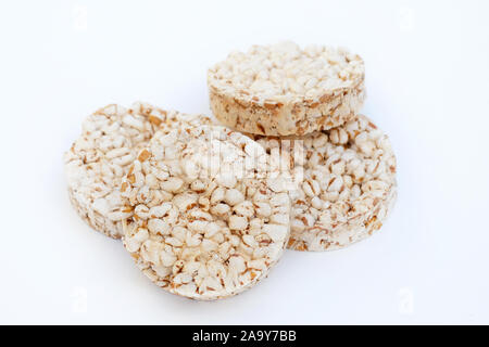 Round crunchy crispbreads on a white background. Round shaped cereal bread, healthy food without yeast. puffed multigrain crispbreads for diet. Stock Photo