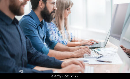 group employees using computers to analyze incoming information Stock Photo