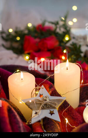 Composition: red roses with boxwood, candles, a garlands , red blanket and star. Stock Photo