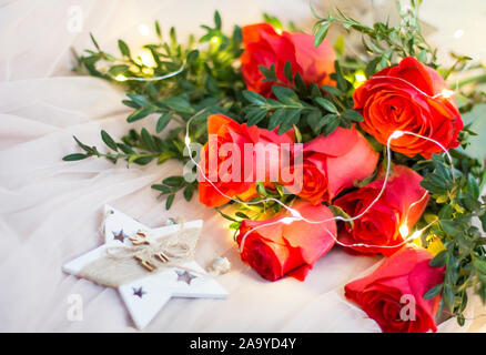 Composition: red roses with boxwood, garlands and star Stock Photo