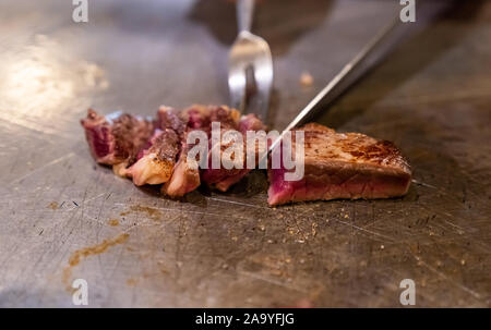 Cooking of beef teppanyaki recipe japanese grilled beef on cooking pan using scraper and knife Stock Photo