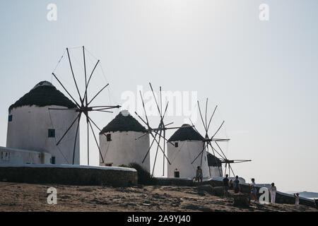 Mykonos Town, Greece - September 20, 2019: People in front of traditional Greek windmills in Hora (Mykonos Town). Being famous attraction, windmills c Stock Photo
