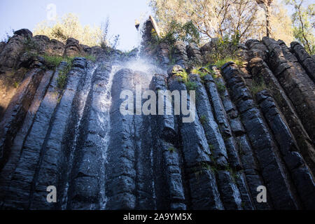 Waterfall and a hanging bridge at basaltic prism canyon at Hidalgo, Mexico. Stock Photo