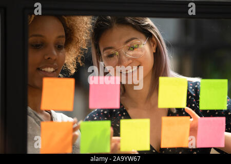 Close up head shot smiling multiracial colleagues working at office. Stock Photo