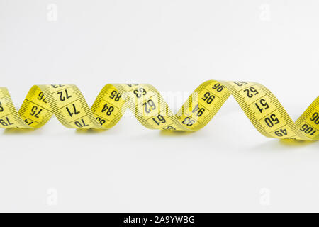 Yellow tape measure in meters and inches in a spiral Stock Photo