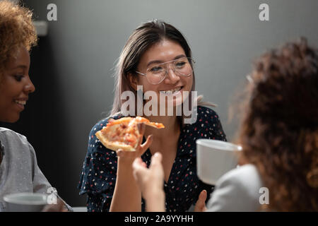 Happy vietnamese employee enjoying lunch time with colleagues. Stock Photo
