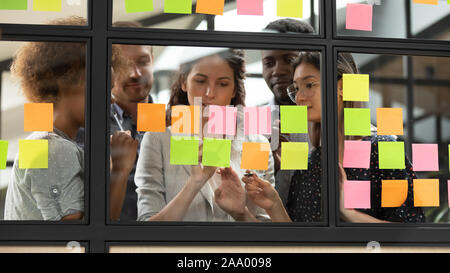 Focused young diverse teammates working with caucasian team leader. Stock Photo