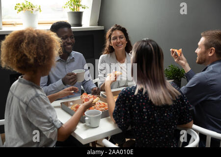 Overjoyed group of mixed race colleagues having fun on friday. Stock Photo
