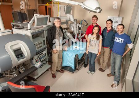 Full-length shot of Professor Russell Taylor, standing with four, smiling, Whiting School of Engineering students, and a da Vinci Surgical Robot, in a mock operating room at the Johns Hopkins University, Baltimore, Maryland, April 6, 2009. From the Homewood Photography Collection. () Stock Photo